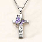 Be Still Butterfly Scripture Cross Necklace on cream background