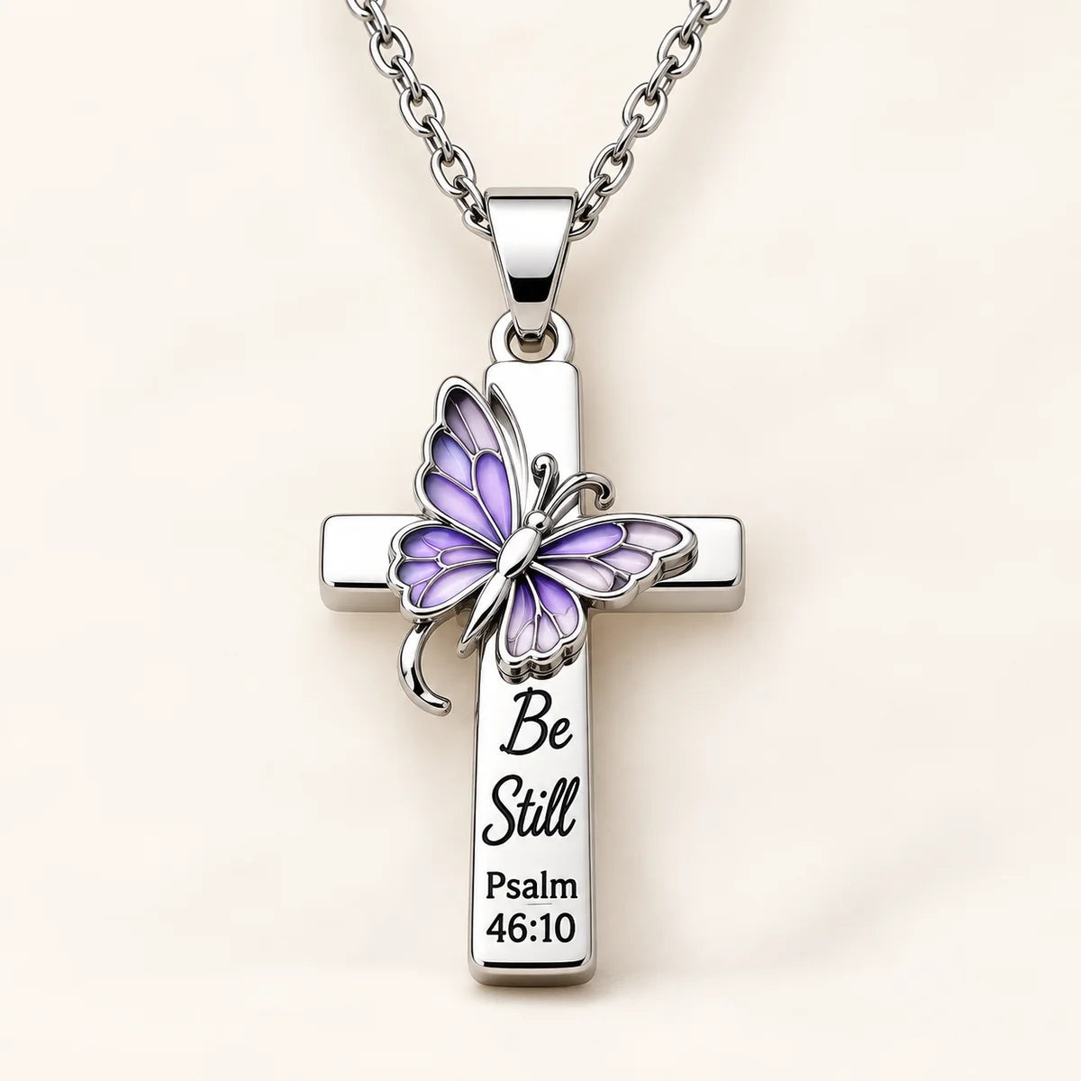 Be Still Butterfly Scripture Cross Necklace on cream background