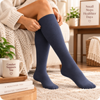 Woman wearing navy Everyday Support knee-high compression socks at home